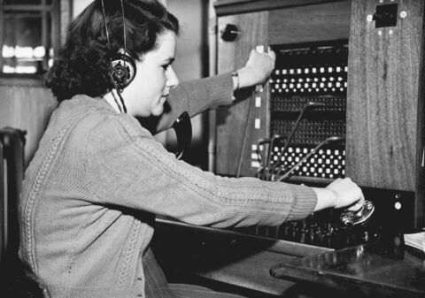 A switchboard operator with headphones, 1950s